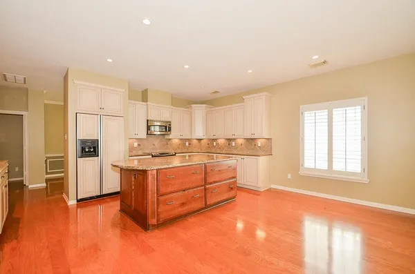 a kitchen with stainless steel appliances granite countertop a stove a sink and a refrigerator