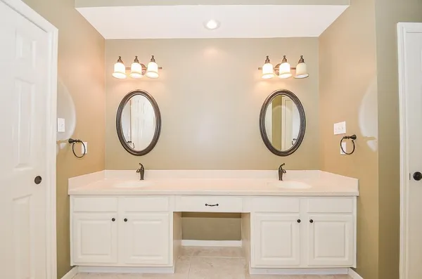 a bathroom with a double vanity sink and a mirror