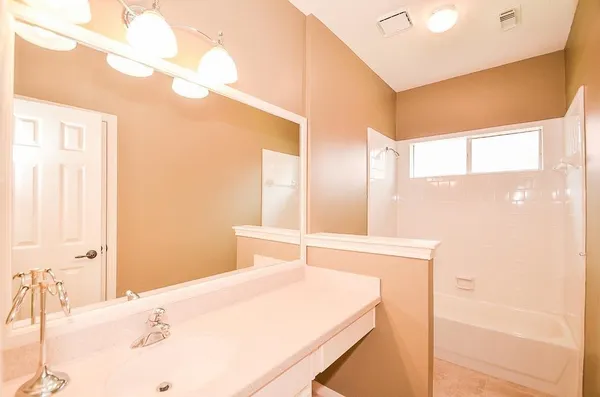 a bathroom with a bathtub sink and a mirror