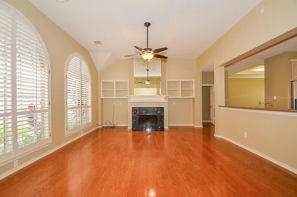 a view of an empty room with a window and fireplace