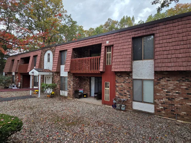 a view of a house with a patio and a yard