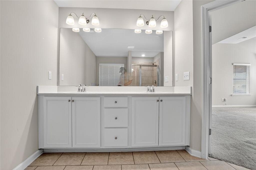 1553 Spring Hollow Way Stone Mountain, GA 30083 - Photo 13 of 27 a bathroom with a sink vanity and a mirror