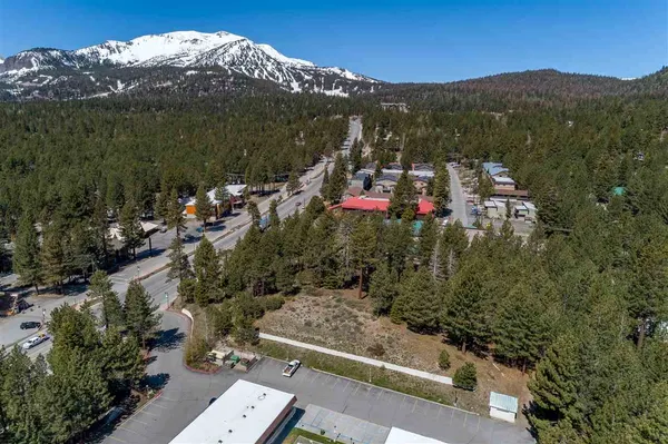 an aerial view of house with yard and mountain view in back