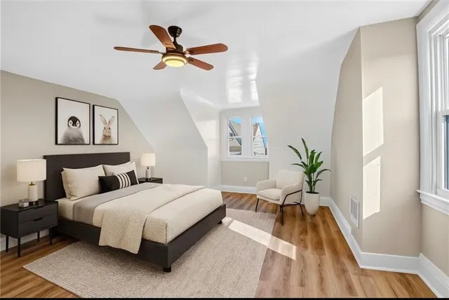 a bedroom with a large bed windows and a potted plant