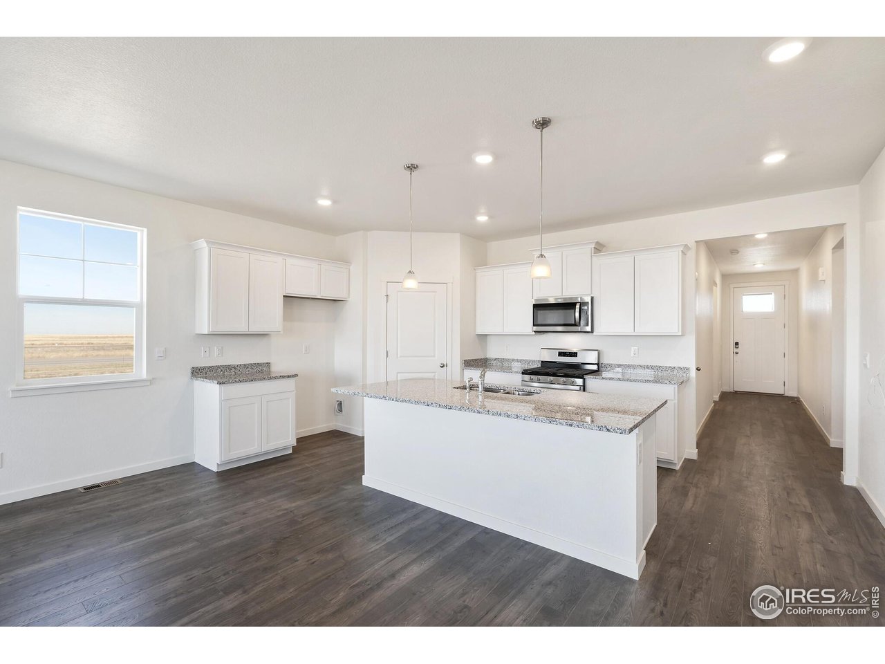 944 London Way Severance, CO 80550 - Photo 11 of 27 a kitchen with kitchen island a sink stainless steel appliances and cabinets