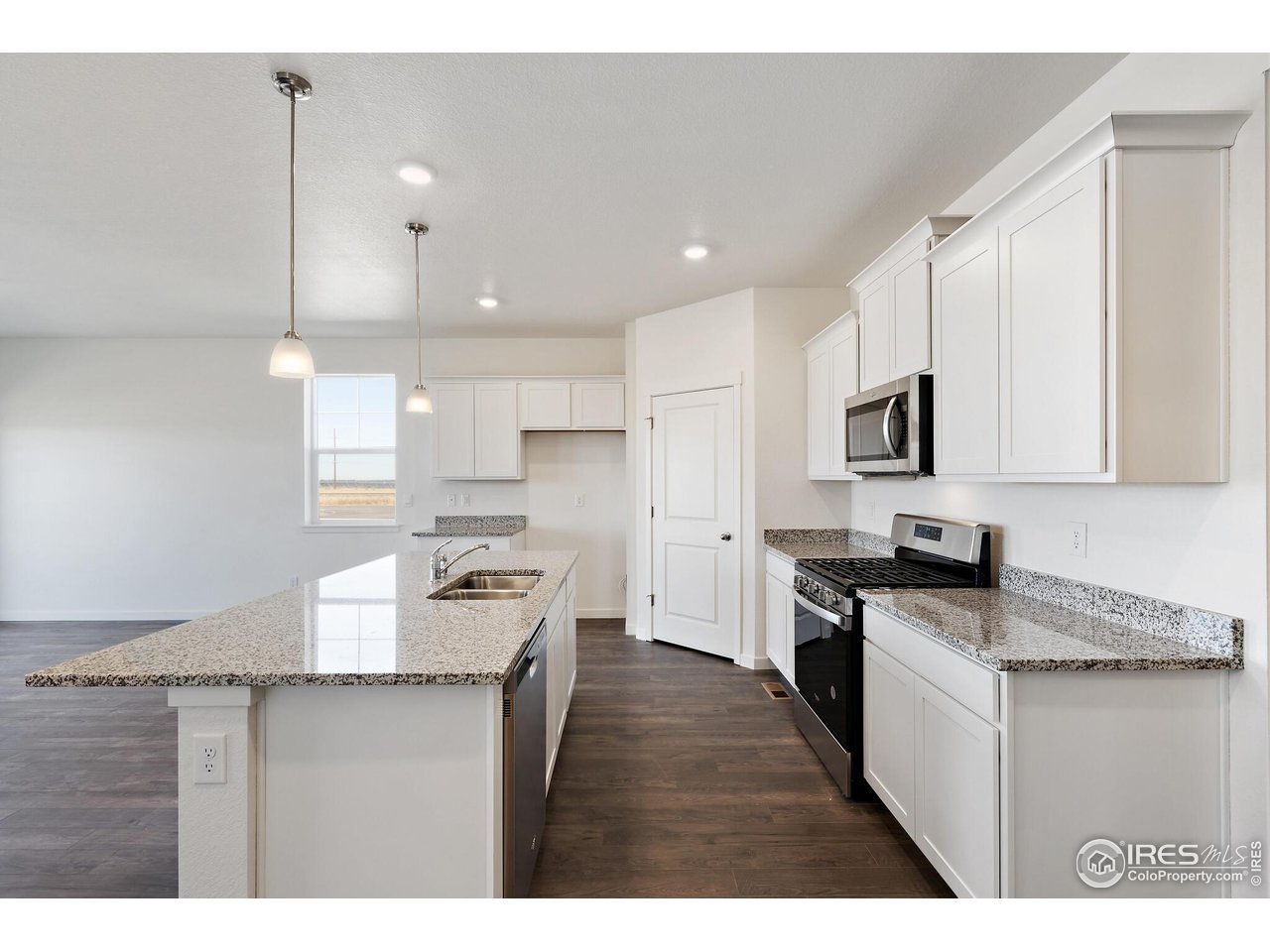 944 London Way Severance, CO 80550 - Photo 12 of 27 a kitchen with granite countertop a stove top oven a sink a counter space and cabinets
