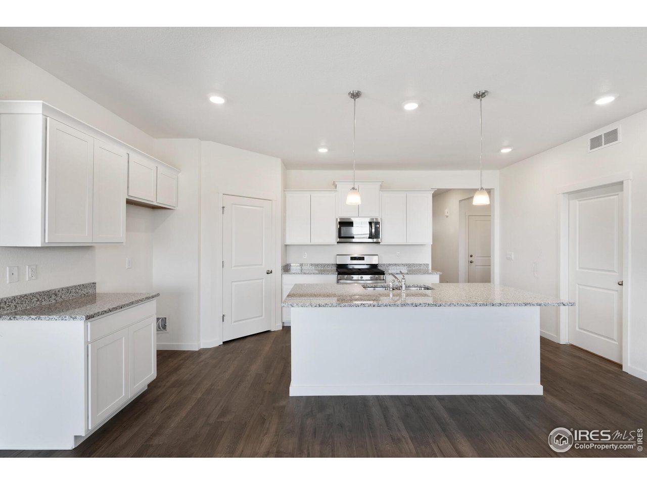 944 London Way Severance, CO 80550 - Photo 14 of 27 a view of a kitchen with kitchen island a sink stainless steel appliances and cabinets
