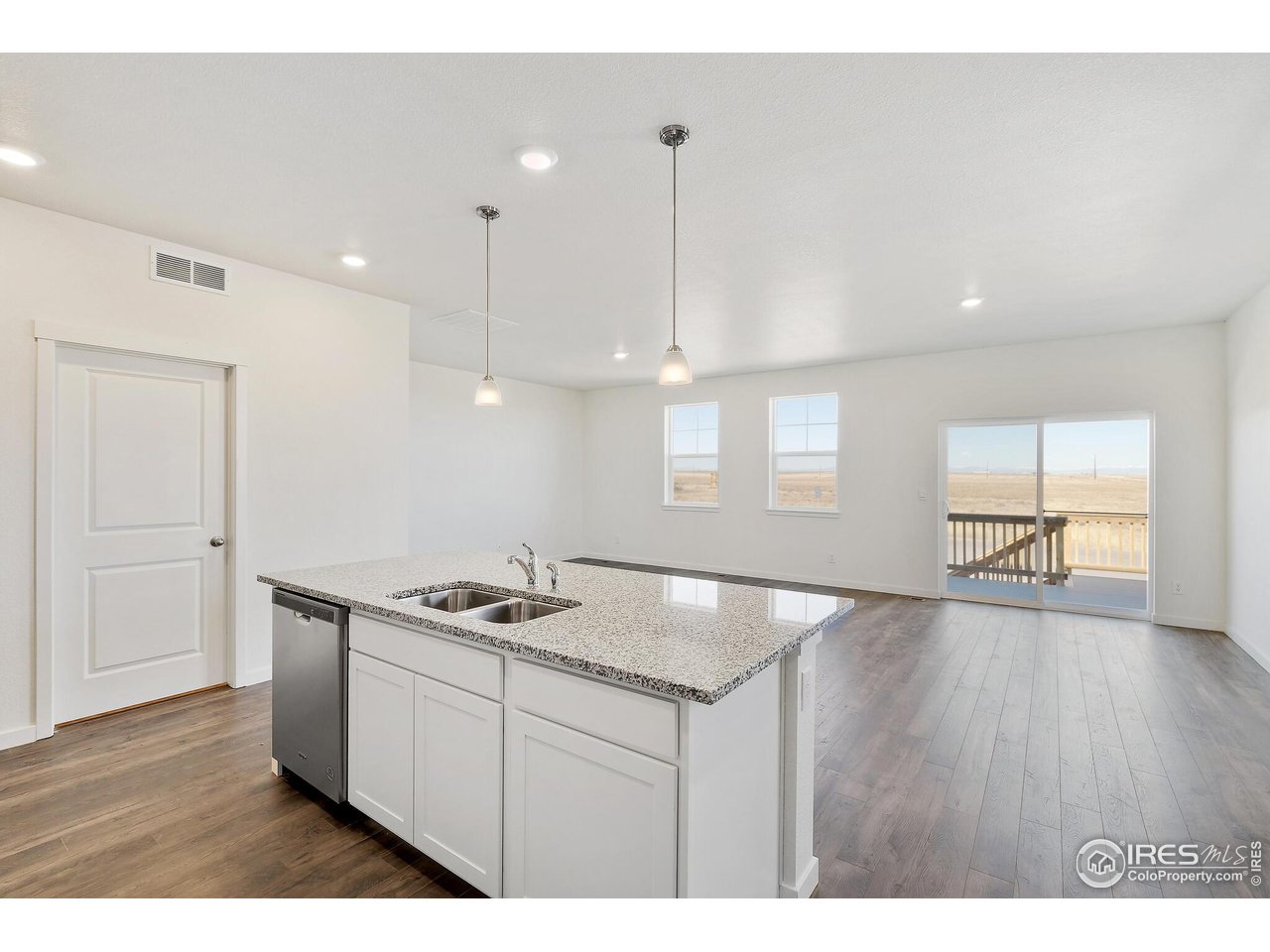 944 London Way Severance, CO 80550 - Photo 17 of 27 a kitchen with stainless steel appliances granite countertop a sink a stove a refrigerator and white cabinets with wooden floor