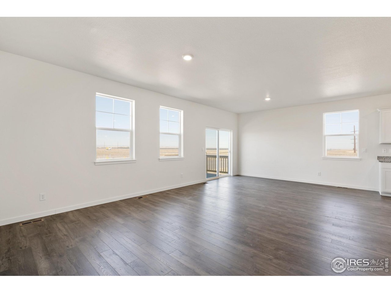 944 London Way Severance, CO 80550 - Photo 8 of 27 a view of empty room with wooden floor and fan