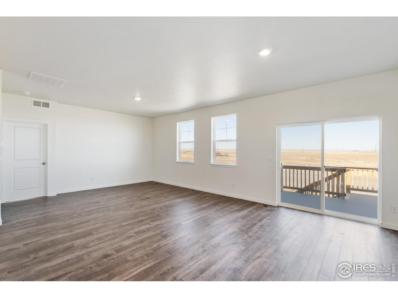 944 London Way Severance, CO 80550 - Photo 9 of 27 wooden floor in an empty room with a window