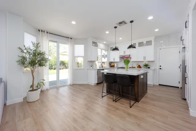 a living room with kitchen island furniture and a potted plant