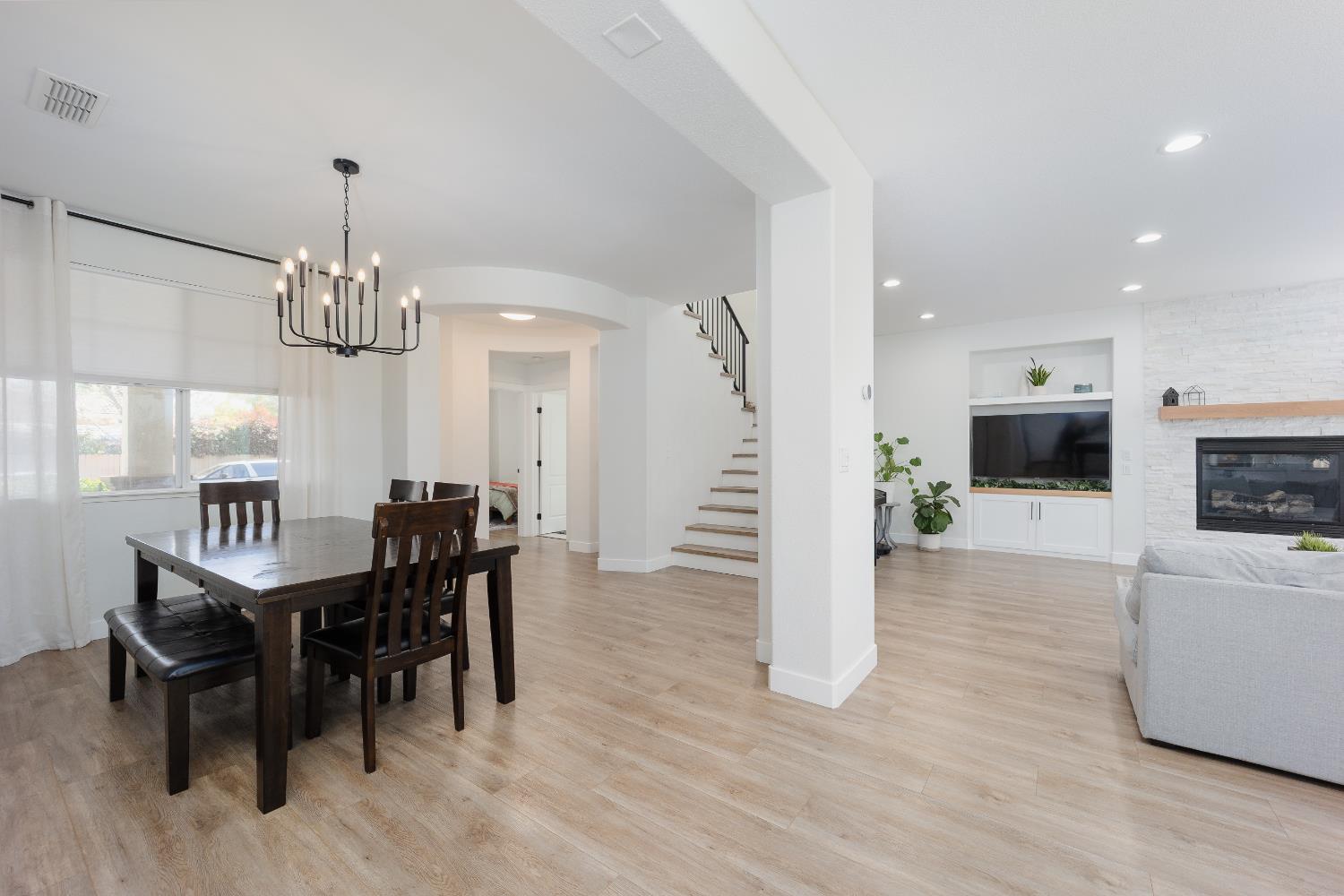 10969 Pelara Way Rancho Cordova, CA 95670 - Photo 18 of 39 a dining room with wooden floor a chandelier a wooden table and chairs