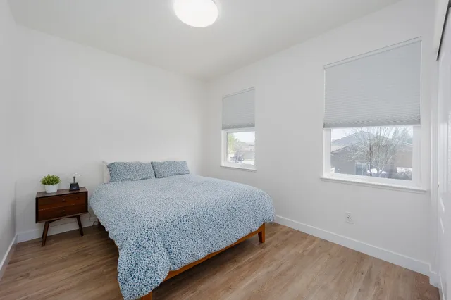 a bedroom with a bed and painting on the wall