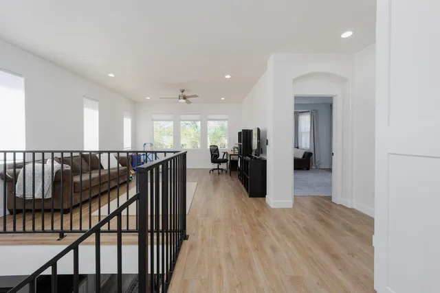 a view of a hallway with kitchen view and wooden floor