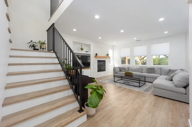 a living room with furniture and a dining table with wooden floor