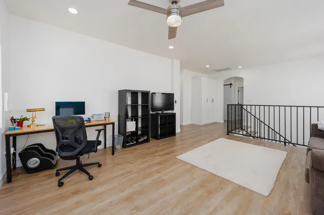 a view of a workspace with furniture and a window