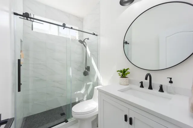 a bathroom with a sink a toilet and a mirror