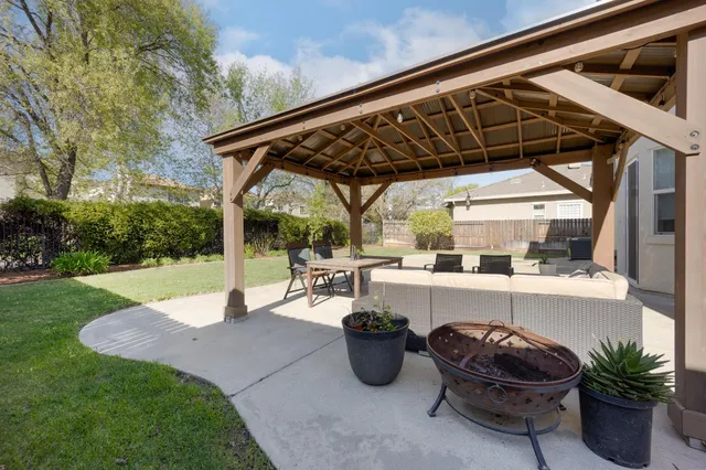 a view of a chair and table in backyard of the house