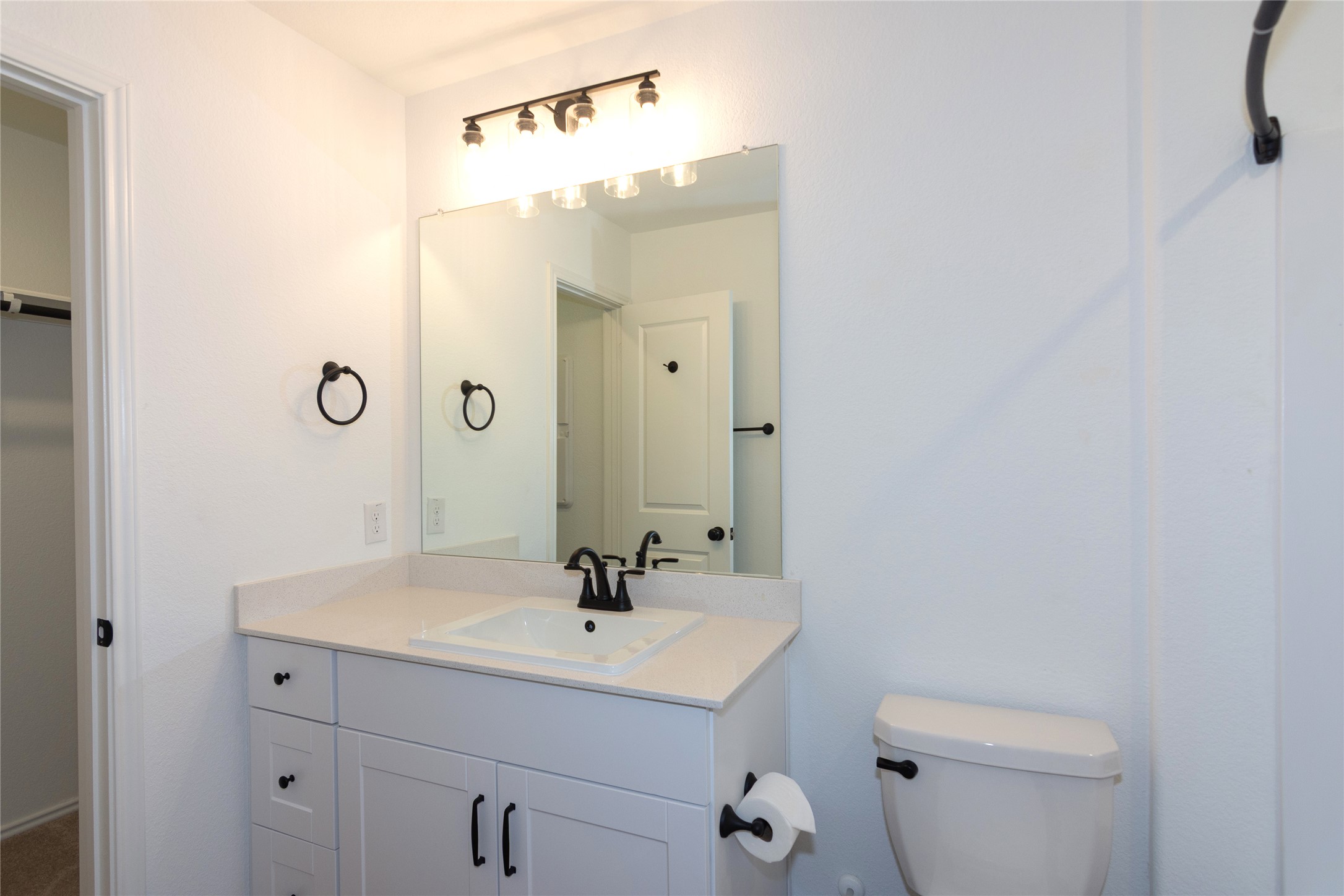 548 Rancho Del Cielo Loop Jarrell, TX 76537 - Photo 18 of 40 Primary bathroom featuring a vanity with white cabinetry, a light-toned countertop, and black hardware