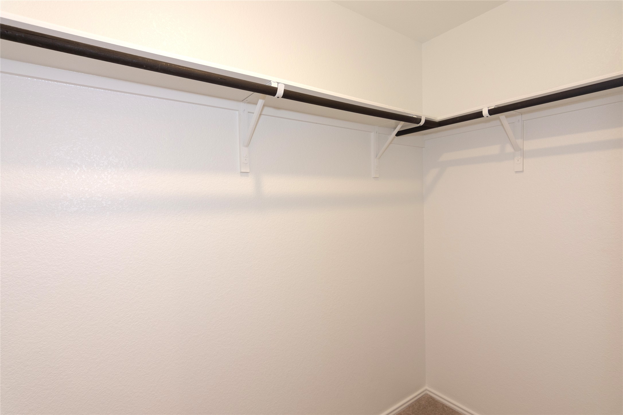 548 Rancho Del Cielo Loop Jarrell, TX 76537 - Photo 19 of 40 Walk-in closet featuring white painted walls, corner shelving, and multiple clothing rods