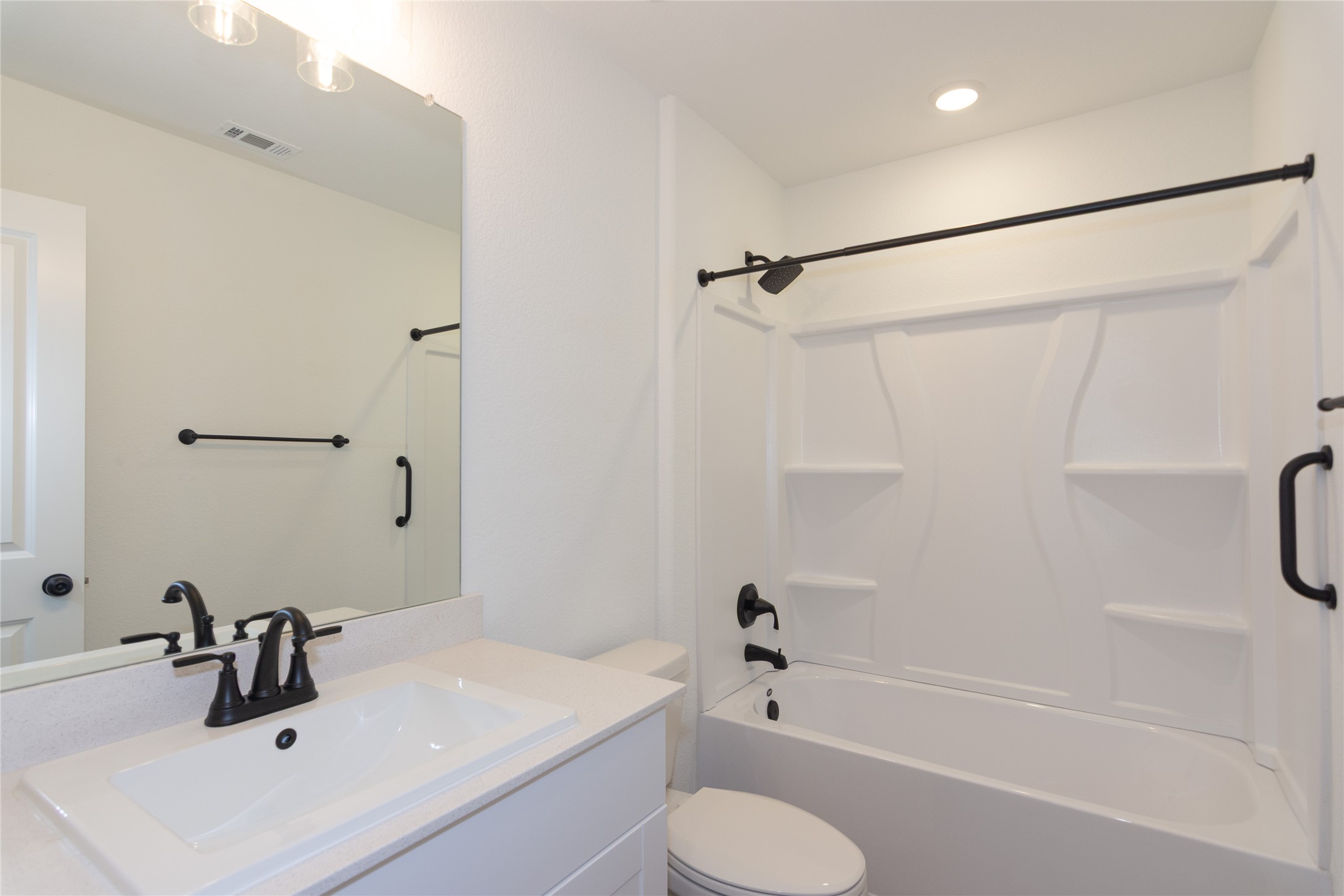 548 Rancho Del Cielo Loop Jarrell, TX 76537 - Photo 22 of 40 Bathroom featuring a white vanity with an integrated sink, matte black faucet, and a large mirror