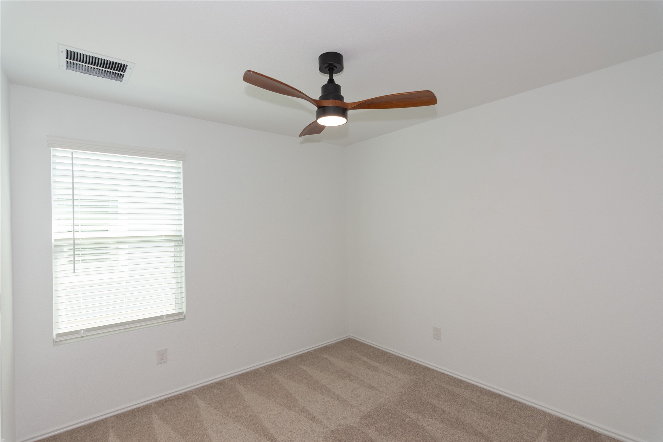 548 Rancho Del Cielo Loop Jarrell, TX 76537 - Photo 23 of 40 Interior room featuring neutral wall paint, a ceiling fan with wood-finish blades, and carpet flooring