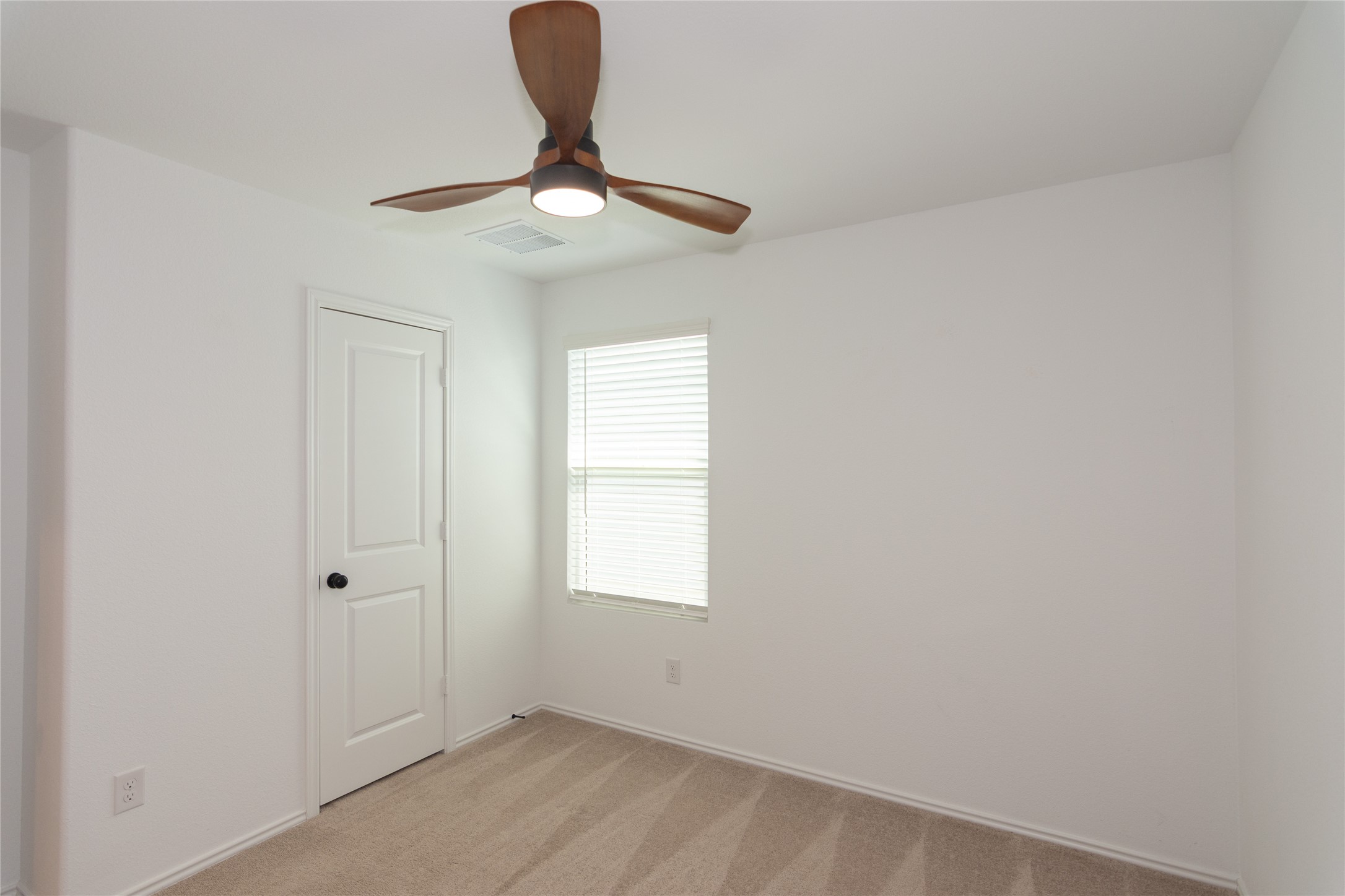 548 Rancho Del Cielo Loop Jarrell, TX 76537 - Photo 24 of 40 Carpeted room featuring a ceiling fan with integrated lighting, a paneled interior door with matte black hardware, and a window with horizontal blinds