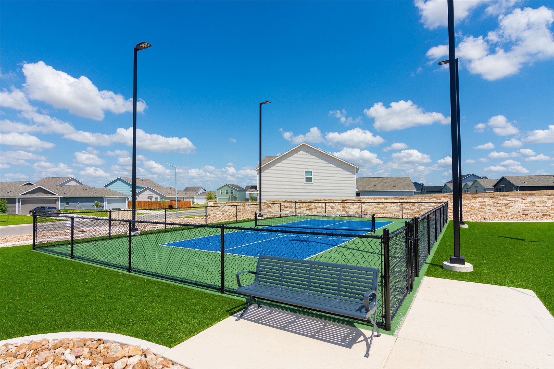 548 Rancho Del Cielo Loop Jarrell, TX 76537 - Photo 38 of 40 Fenced court featuring a blue playing surface with white lines, surrounded by green turf