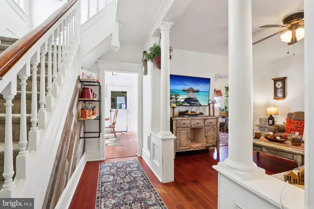 a view of hallway with wooden floor and furniture