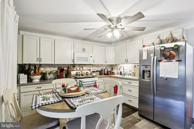 a kitchen with stainless steel appliances granite countertop a dining table and chairs