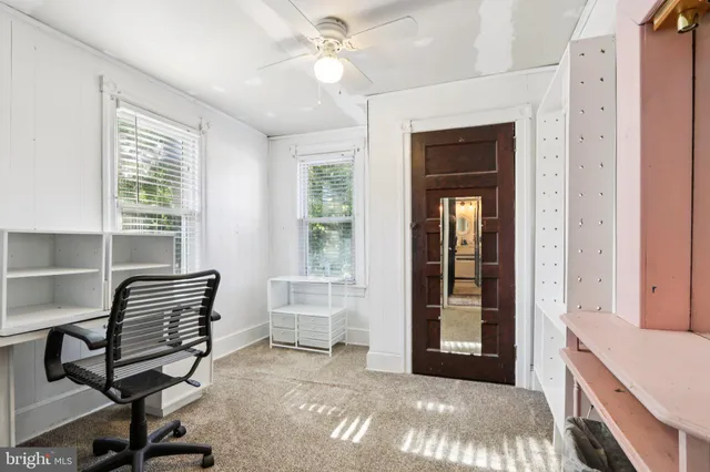 a view of a workspace with furniture and a window