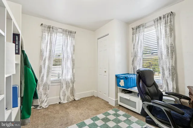 a room with lots of white furniture and a chair
