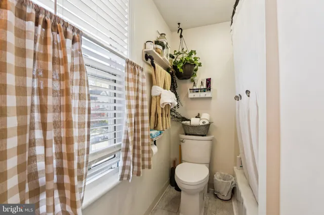 a bedroom with a bed large window and couch