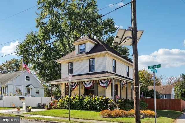 a front view of a white house with a yard