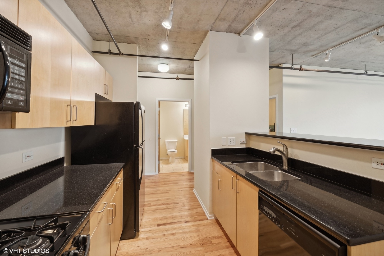 700 West Van Buren Street, Unit 1002 Chicago, IL 60607 - Photo 11 of 18 a kitchen with stainless steel appliances a sink and a refrigerator