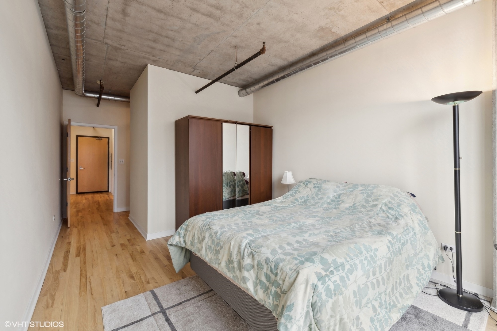 700 West Van Buren Street, Unit 1002 Chicago, IL 60607 - Photo 14 of 18 a bedroom with a bed and a mirror