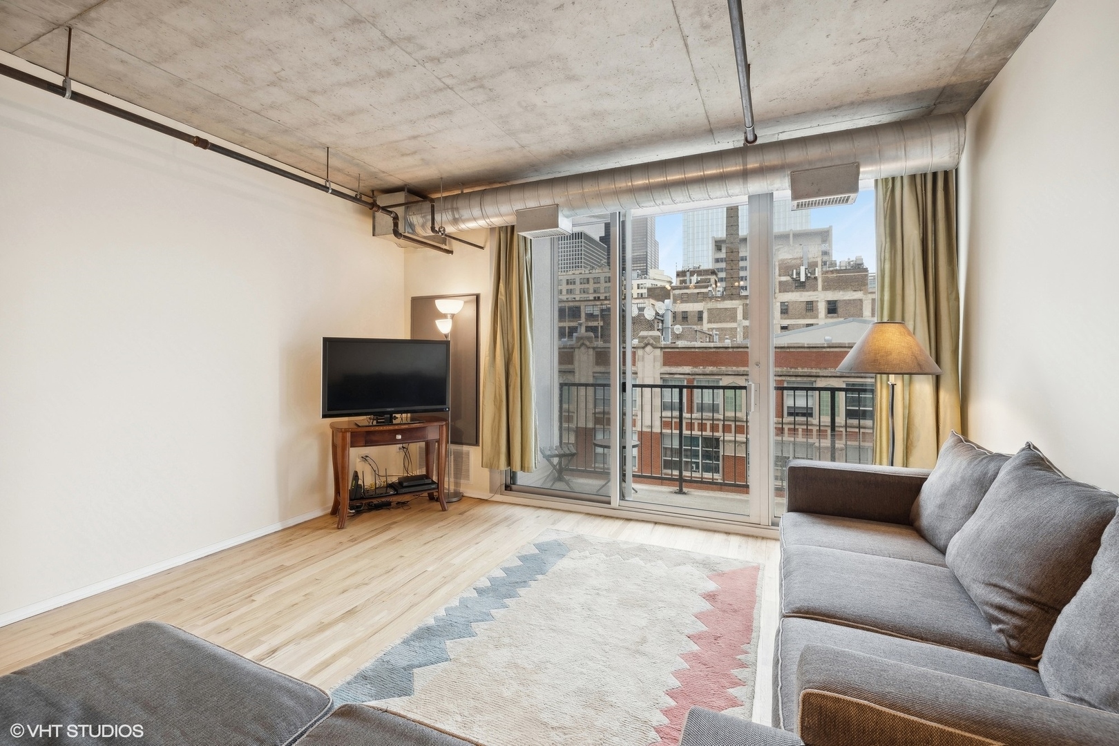 700 West Van Buren Street, Unit 1002 Chicago, IL 60607 - Photo 2 of 18 a living room with furniture a flat screen tv and a large window