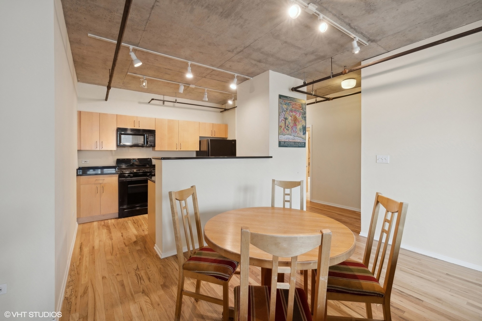 700 West Van Buren Street, Unit 1002 Chicago, IL 60607 - Photo 5 of 18 a kitchen with stainless steel appliances granite countertop a dining table chairs and refrigerator