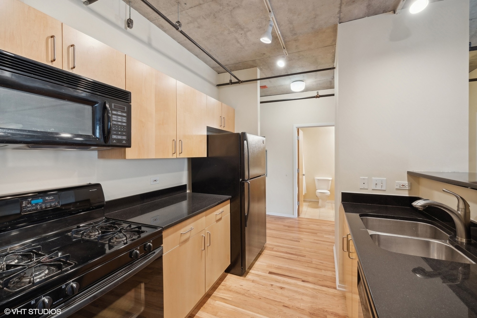 700 West Van Buren Street, Unit 1002 Chicago, IL 60607 - Photo 10 of 18 a kitchen with granite countertop stainless steel appliances and wooden cabinets