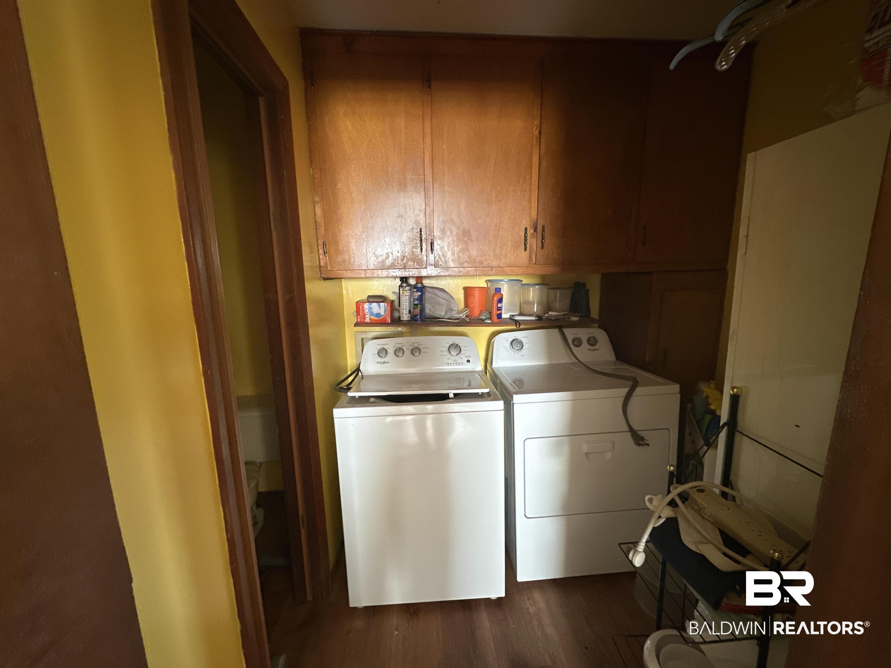 9520 C Four Mile Road Irvington, AL 36544 - Photo 18 of 32 Laundry room with cabinets, dark hardwood / wood-style floors, and independent washer and dryer