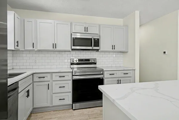 a kitchen with kitchen island a sink stainless steel appliances and cabinets