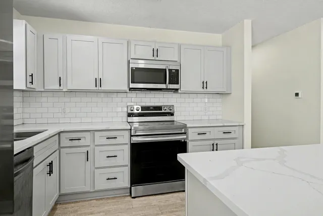 a kitchen with kitchen island a sink stainless steel appliances and cabinets