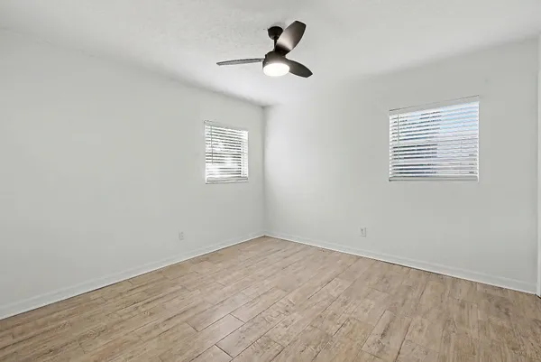 a view of a hallway with wooden floor and closet