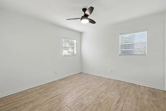 a view of a hallway with wooden floor and closet