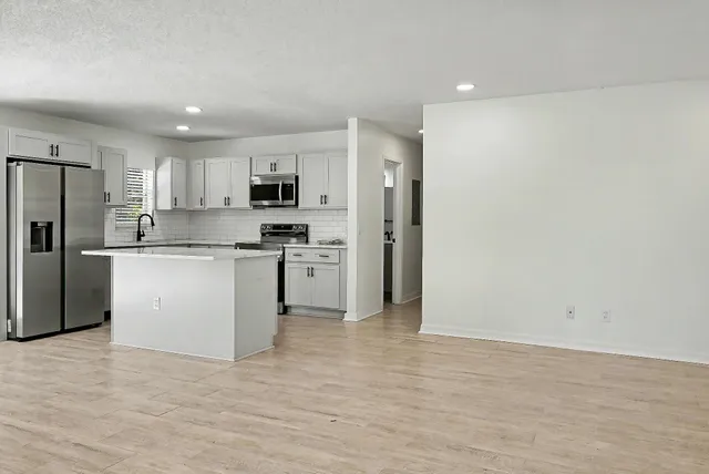 a kitchen with stainless steel appliances a refrigerator sink and microwave