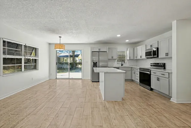 a kitchen with stainless steel appliances a refrigerator sink and cabinets