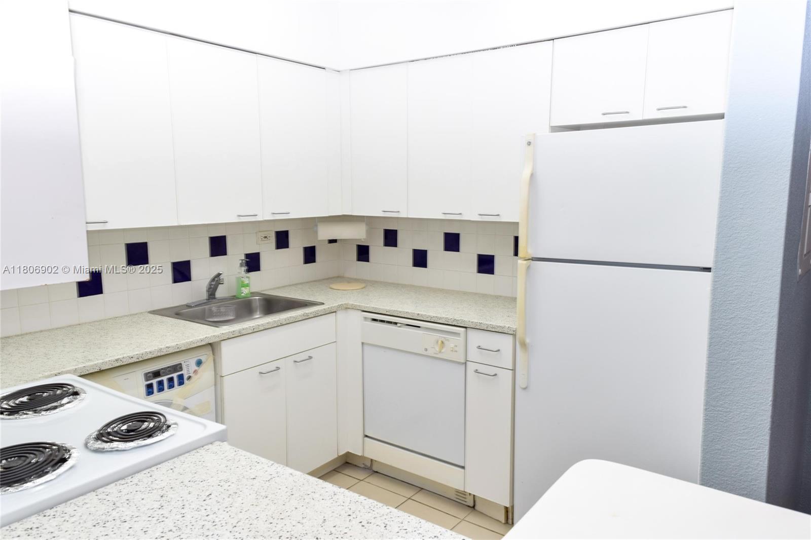 1500 Bay Road, Unit 1532S Miami Beach, FL 33139 - Photo 18 of 50 a kitchen with white cabinets and white appliances