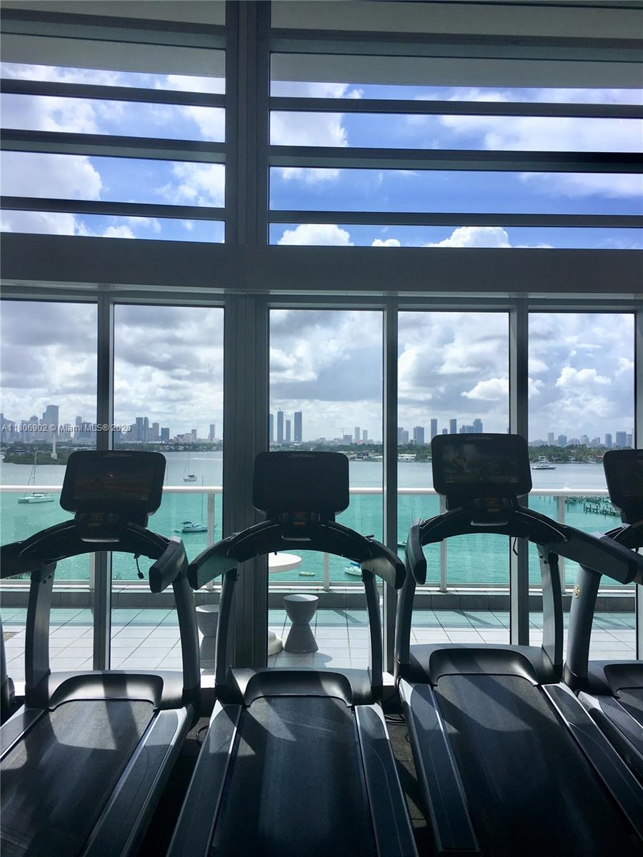 1500 Bay Road, Unit 1532S Miami Beach, FL 33139 - Photo 48 of 50 a view of a room with gym equipment and floor to ceiling windows