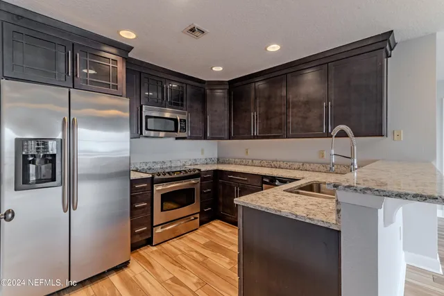a kitchen with granite countertop stainless steel appliances and wooden cabinets