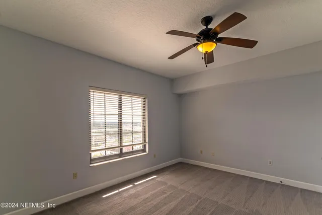 a view of wooden floor and a chandelier fan in a room
